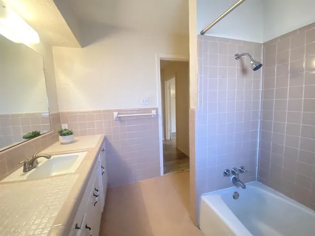 a bathroom with a tub sink and mirror