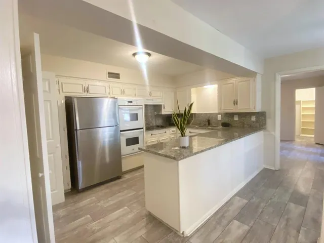 a kitchen with stainless steel appliances granite countertop a refrigerator and a sink