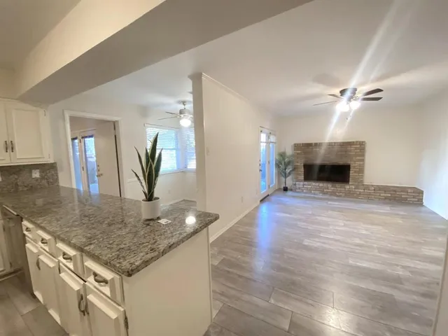 an open kitchen with fireplace and wooden floor