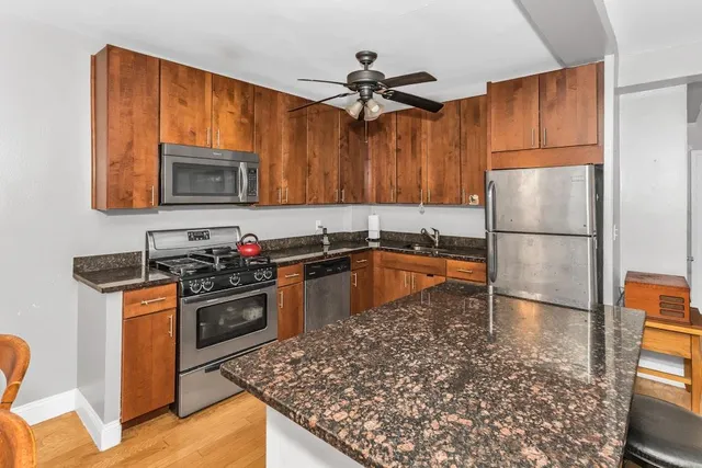 a kitchen with granite countertop a stove top oven and a refrigerator