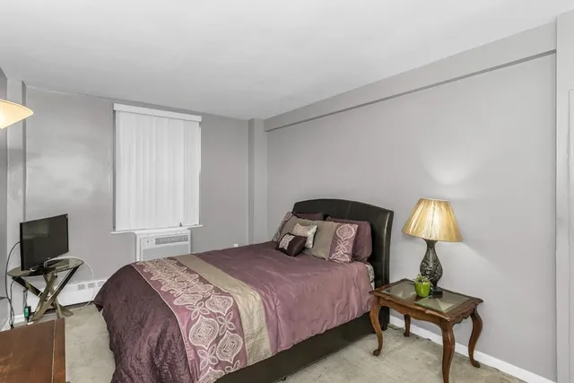 a bedroom with a bed and a lamp on table