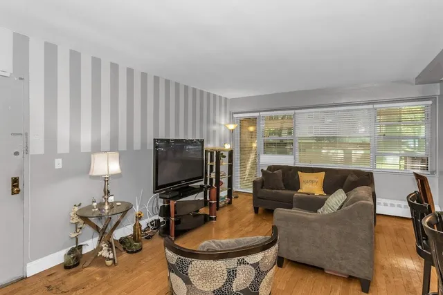 a living room with furniture a flat screen tv and a large window