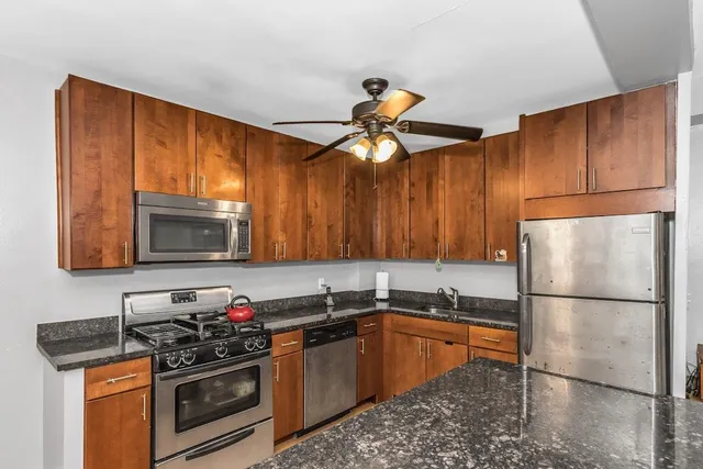 a kitchen with stainless steel appliances granite countertop a stove a sink dishwasher and a refrigerator