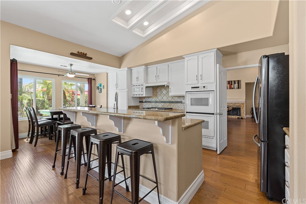 1879 Apostle Lane Riverside, CA 92506 - Photo 13 of 49 a kitchen with kitchen island granite countertop wooden floors and stainless steel appliances