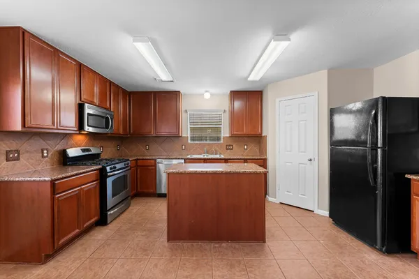 a kitchen with stainless steel appliances granite countertop a refrigerator stove and sink