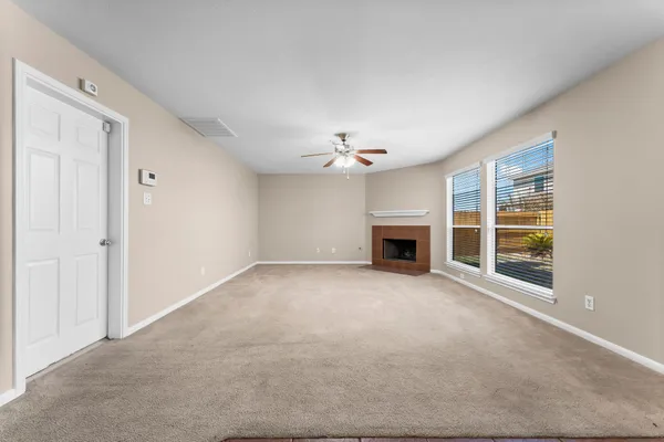 a view of an empty room with a fireplace and a window