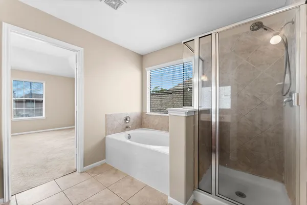 a white bath tub sitting next to a shower