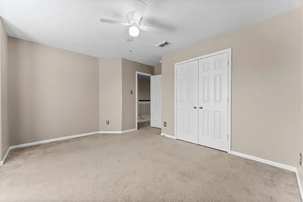 a view of an empty room with a ceiling fan