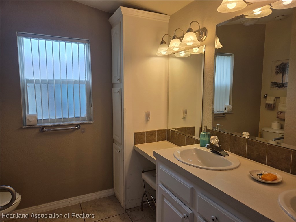 3312 Beartooth Pass Sebring, FL 33872 - Photo 24 of 39 a bathroom with a sink double vanity and a mirror