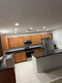 a kitchen with stainless steel appliances granite countertop a sink and a refrigerator