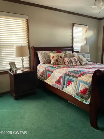 a bedroom with a bed dresser and window