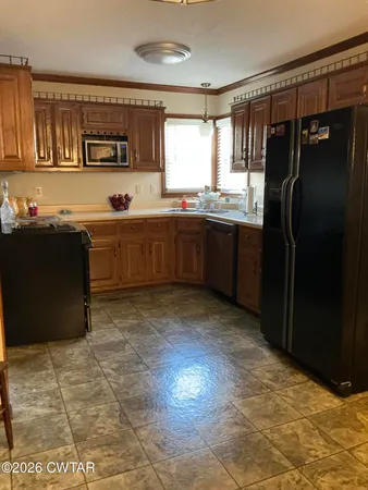 a kitchen with stainless steel appliances granite countertop a refrigerator and a stove top oven