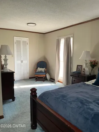a bedroom with a bed and a large mirror on the dresser
