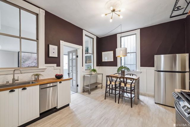 a kitchen with a table chairs refrigerator and cabinets