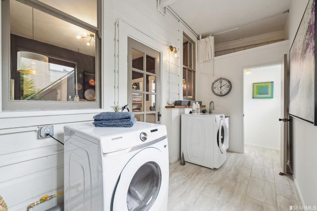 a view of washer and dryer with kitchen in the background