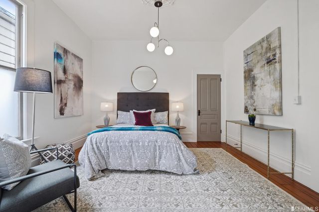 a bedroom with a large bed and a chandelier