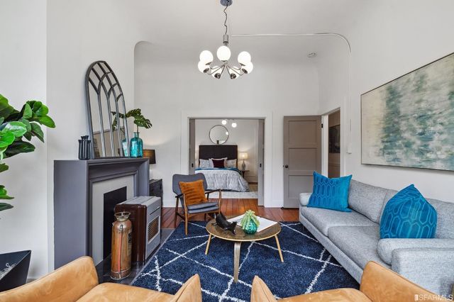 a living room with furniture a chandelier and a fireplace