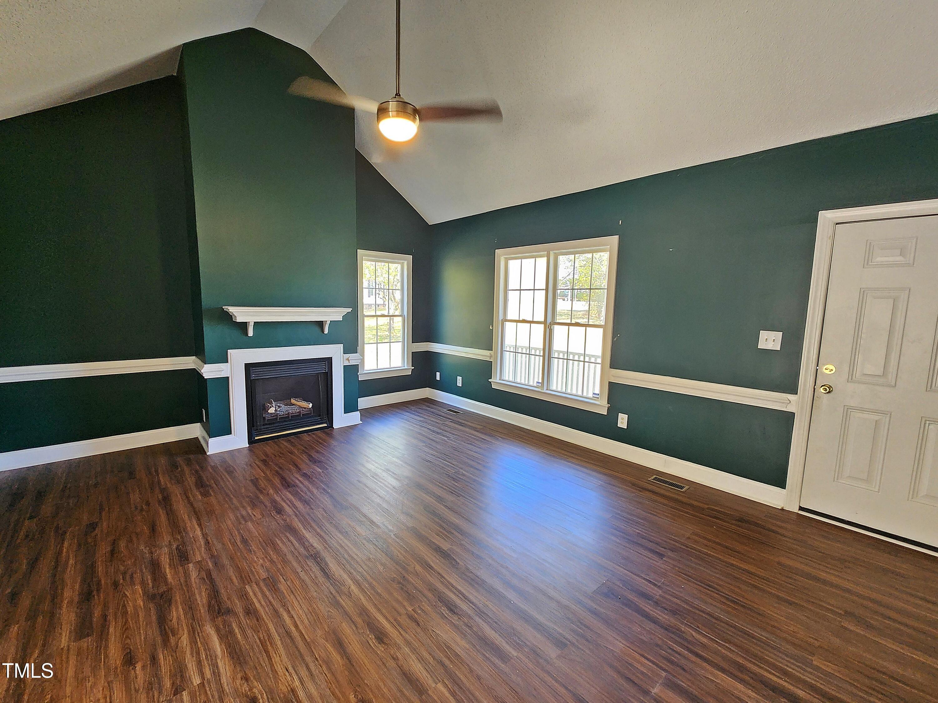120 Keith Court Willow Spring, NC 27592 - Photo 10 of 25 an empty room with wooden floor fireplace and windows