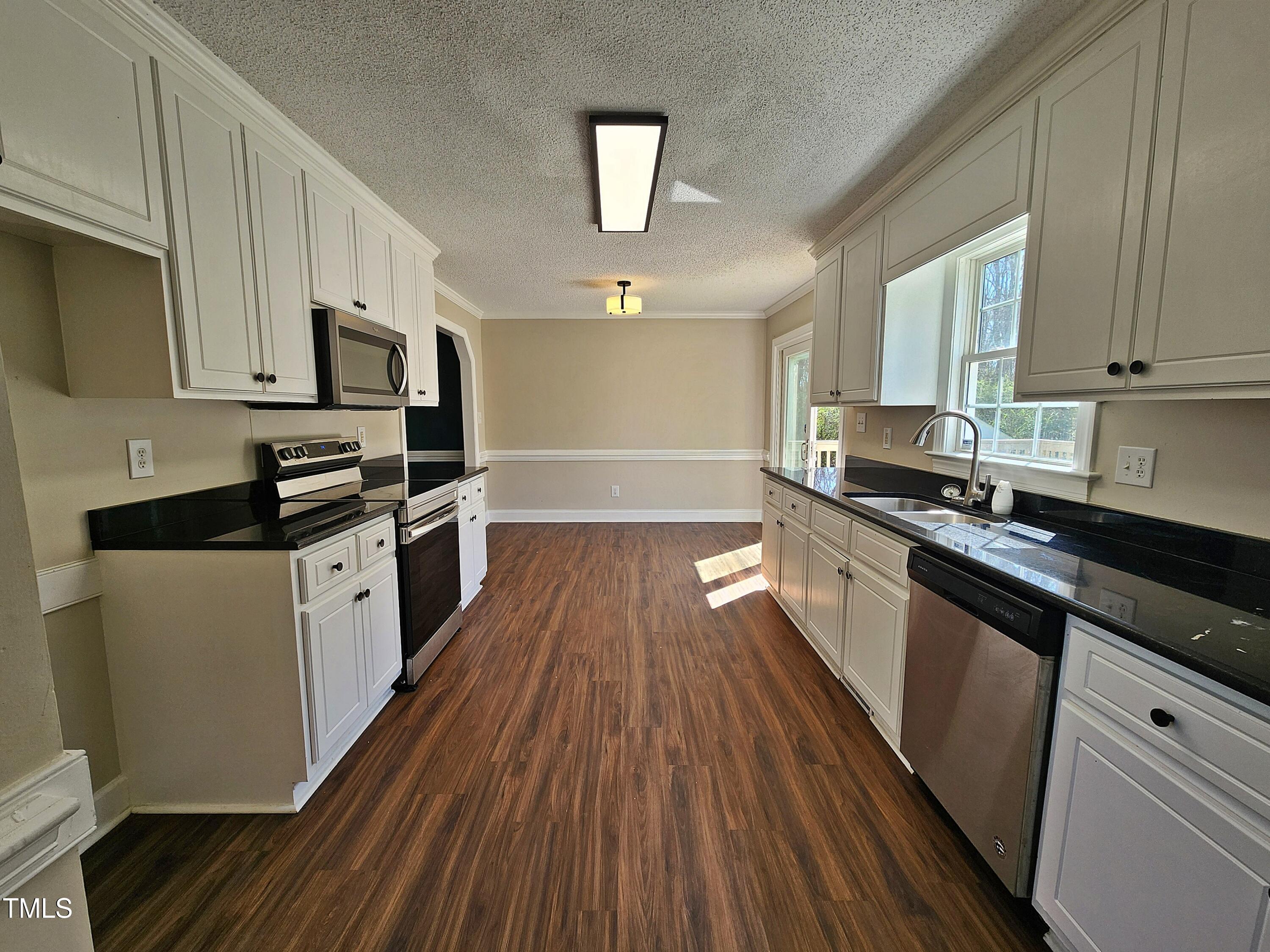 120 Keith Court Willow Spring, NC 27592 - Photo 12 of 25 a kitchen with stainless steel appliances a microwave a stove a sink dishwasher and cabinets with wooden floor