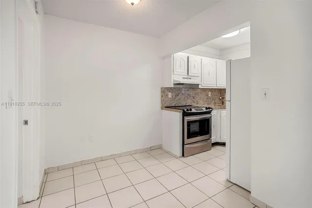a kitchen with granite countertop white cabinets and stainless steel appliances
