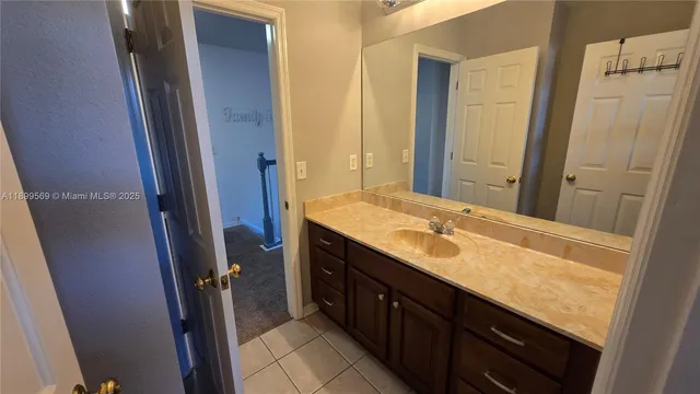a bathroom with a granite countertop sink and a mirror