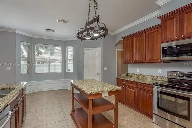 a kitchen with stainless steel appliances granite countertop a stove a sink dishwasher and a microwave oven with cabinets