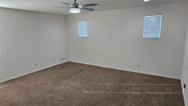 an empty room with a fan and a window