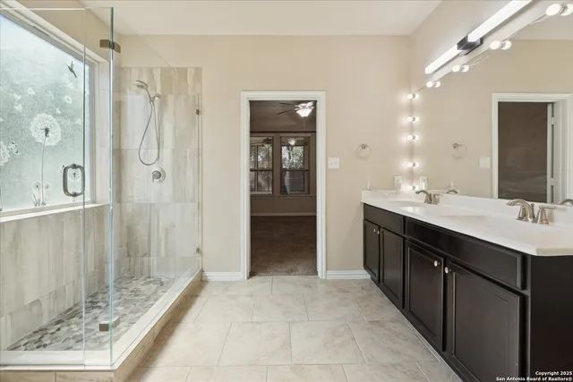 a bathroom with a double sink shower and a mirror