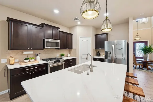 a kitchen with stainless steel appliances kitchen island granite countertop a sink a stove and cabinets