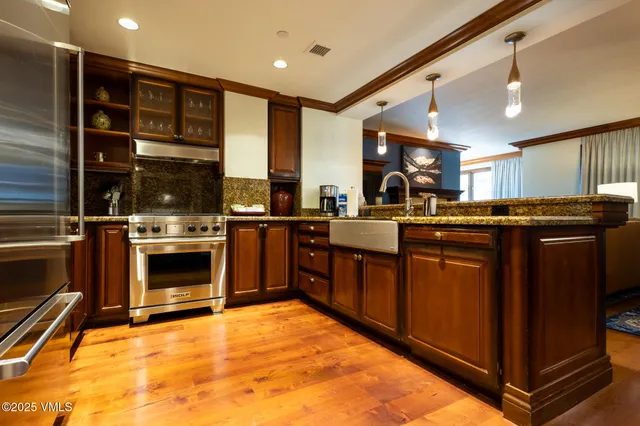 a kitchen with stainless steel appliances granite countertop a stove a sink and a microwave