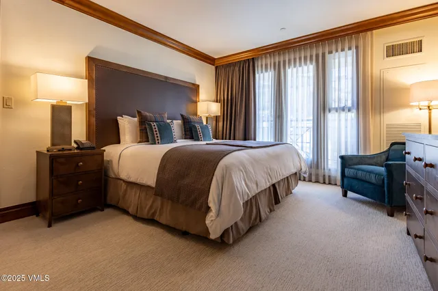 a bedroom with a bed and a dresser next to a window