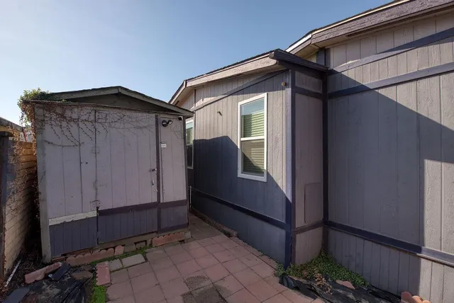 a view of backyard with small cabin and wooden fencing