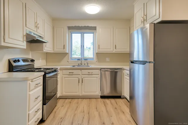 a kitchen with white cabinets and white appliances