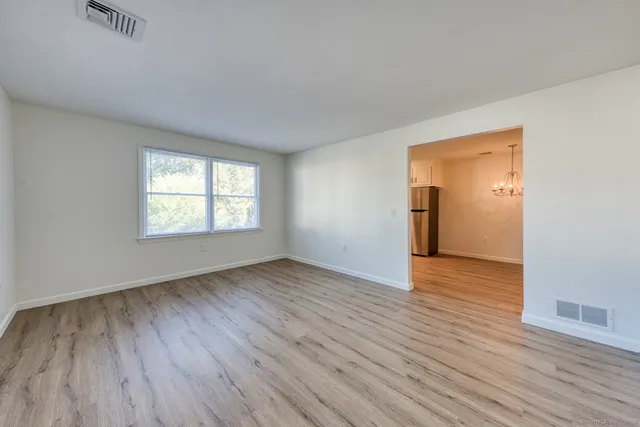 an empty room with wooden floor and a window