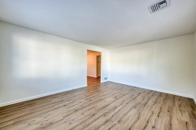 a view of an empty room and wooden floor
