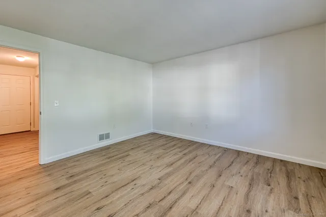 a view of an empty room with wooden floor