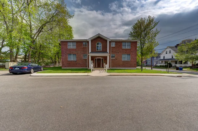 a yellow house with trees in front of it