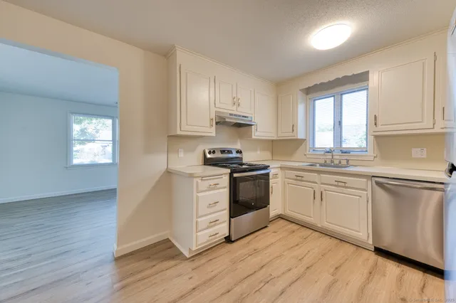 a kitchen with granite countertop white cabinets and white appliances