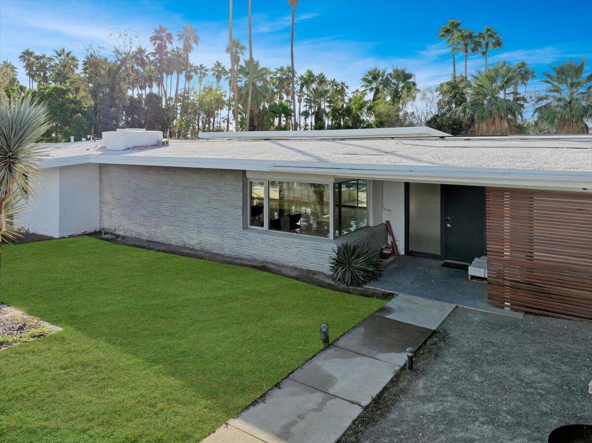 447 West Mariscal Road Palm Springs, CA 92262 - Photo 10 of 22 a view of a white house next to a yard with potted plants