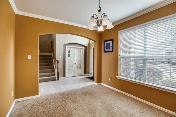 a view of a livingroom with a chandelier fan and windows