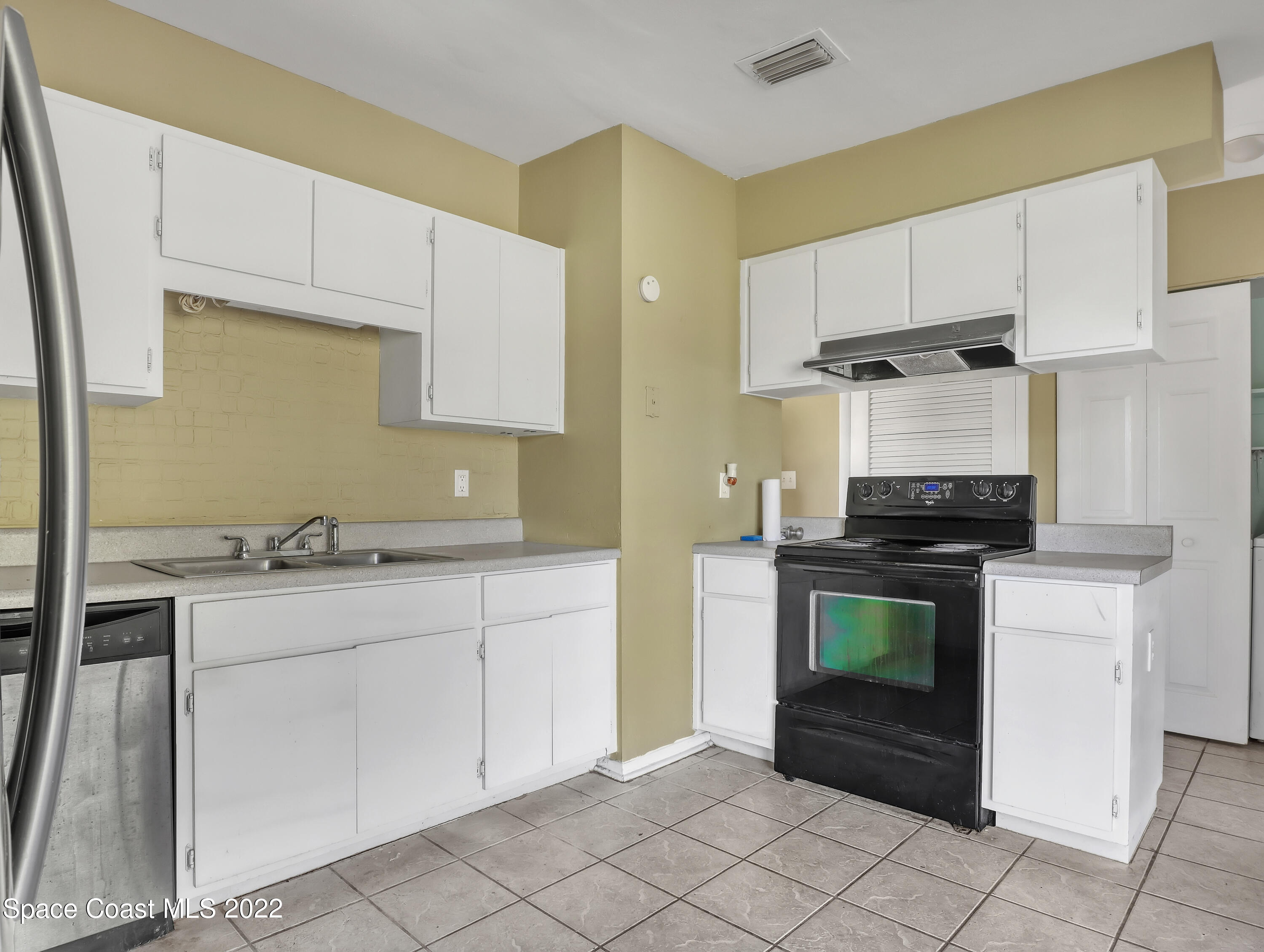 2808 Starlight Circle Northeast Palm Bay, FL 32905 - Photo 13 of 33 a kitchen with granite countertop a stove sink and cabinets