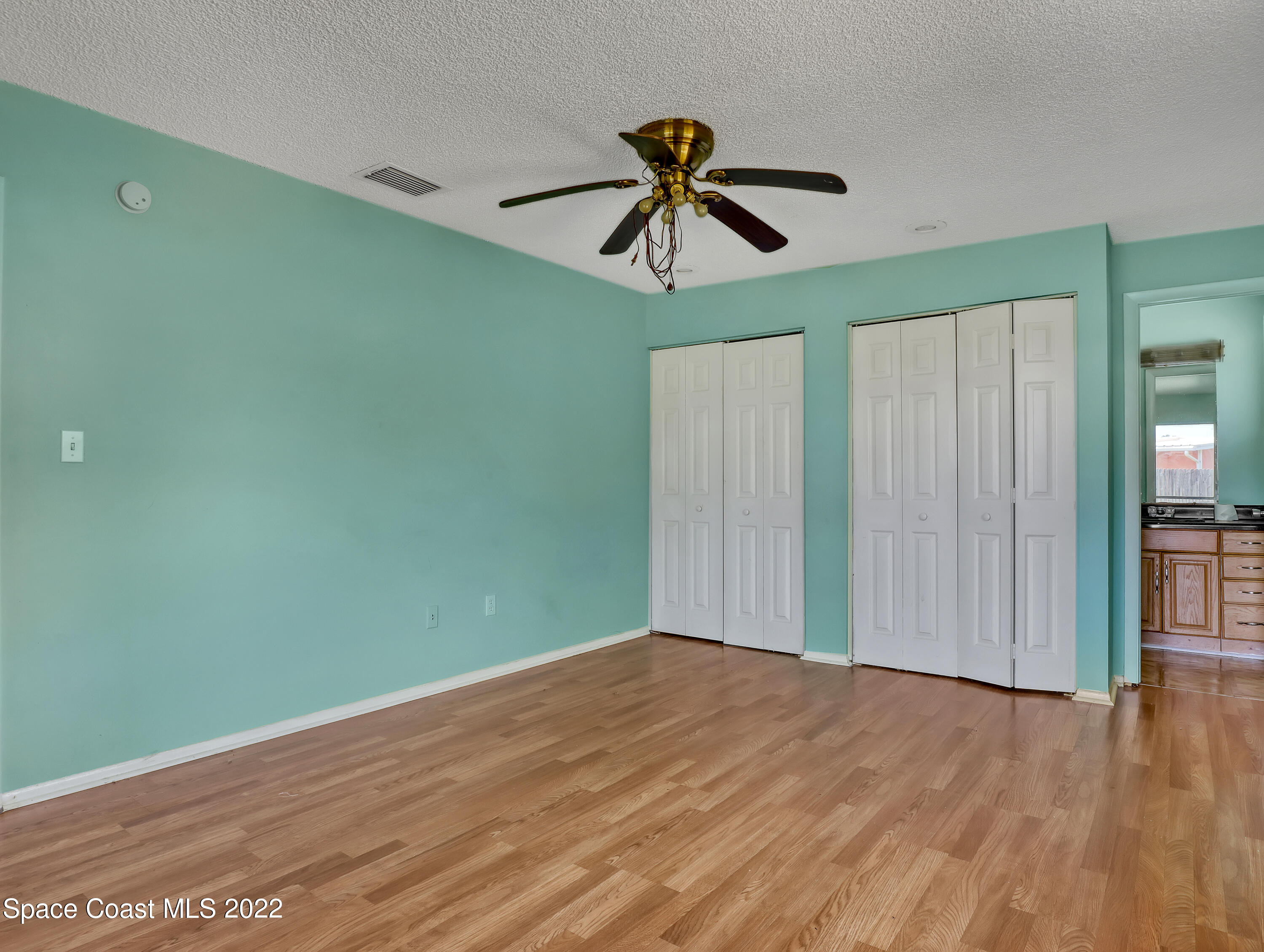 2808 Starlight Circle Northeast Palm Bay, FL 32905 - Photo 18 of 33 a view of empty room with wooden floor and fan