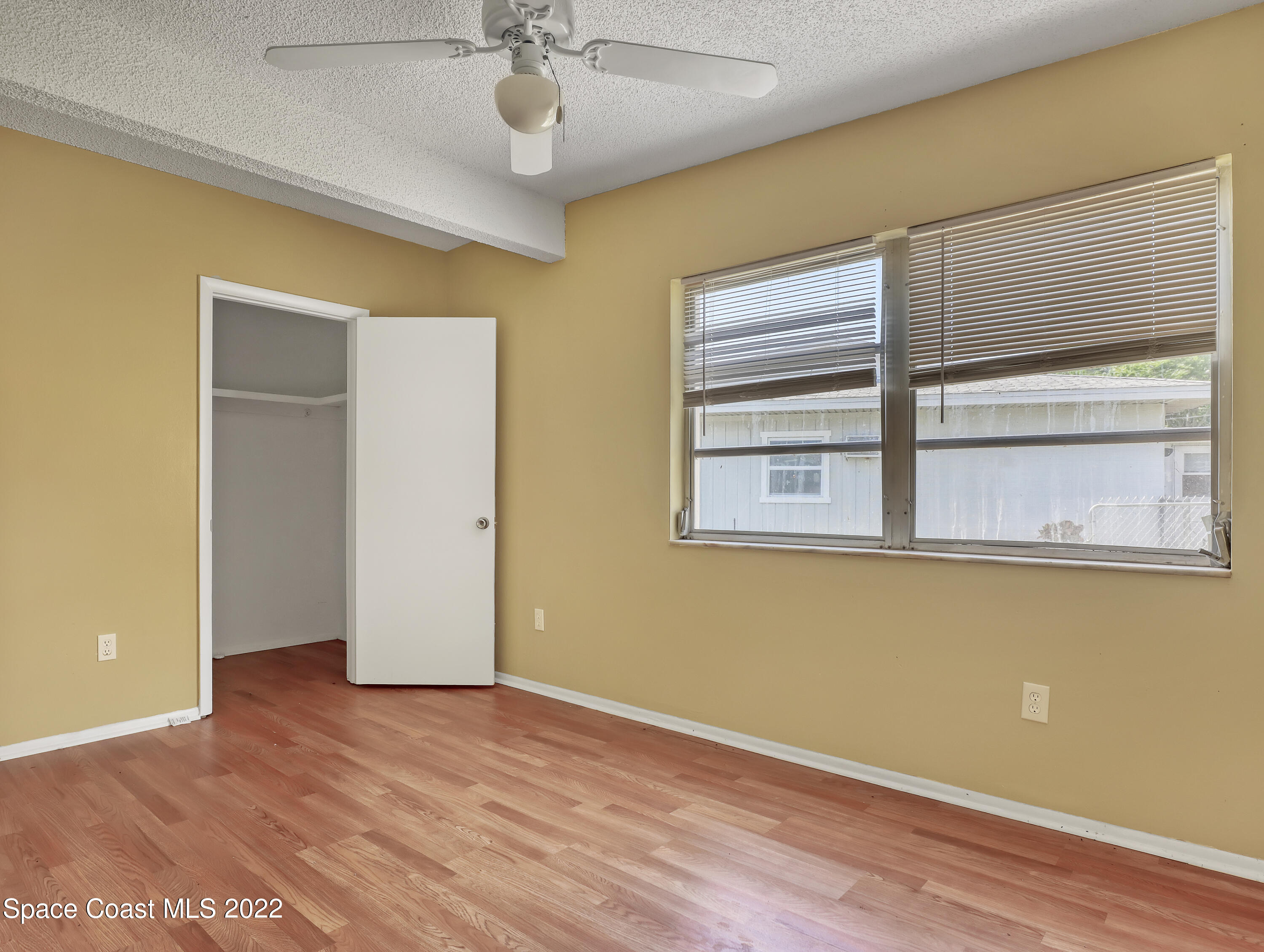 2808 Starlight Circle Northeast Palm Bay, FL 32905 - Photo 26 of 33 a view of an empty room with wooden floor and a window