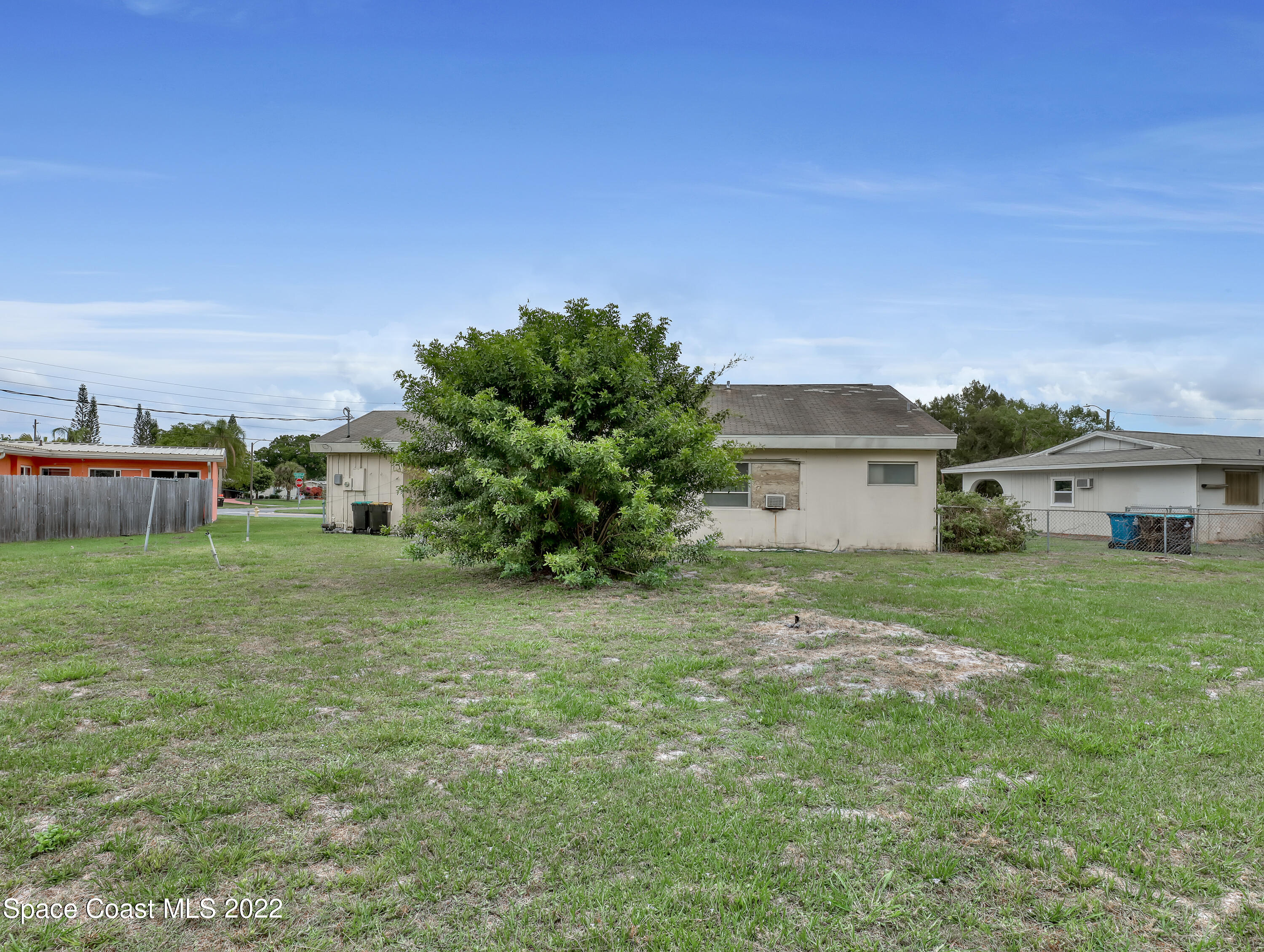 2808 Starlight Circle Northeast Palm Bay, FL 32905 - Photo 32 of 33 a yellow house sitting in middle of the green field