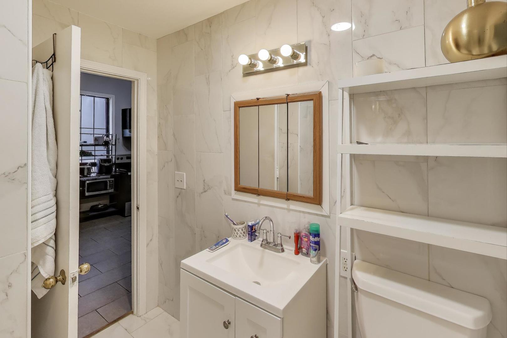 1845 North Albany Avenue, Unit 1 Chicago, IL 60647 - Photo 16 of 24 a bathroom with a sink and a mirror