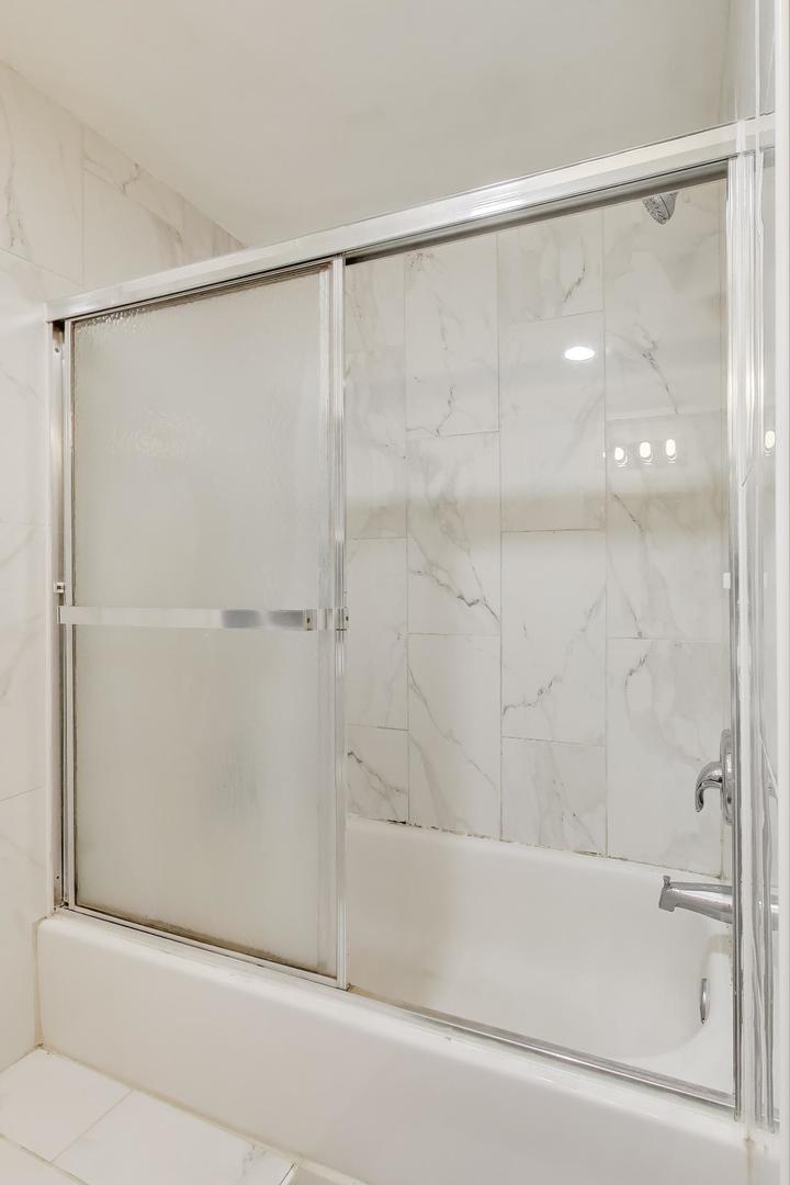 1845 North Albany Avenue, Unit 1 Chicago, IL 60647 - Photo 17 of 24 a bathroom with a shower and a glass door