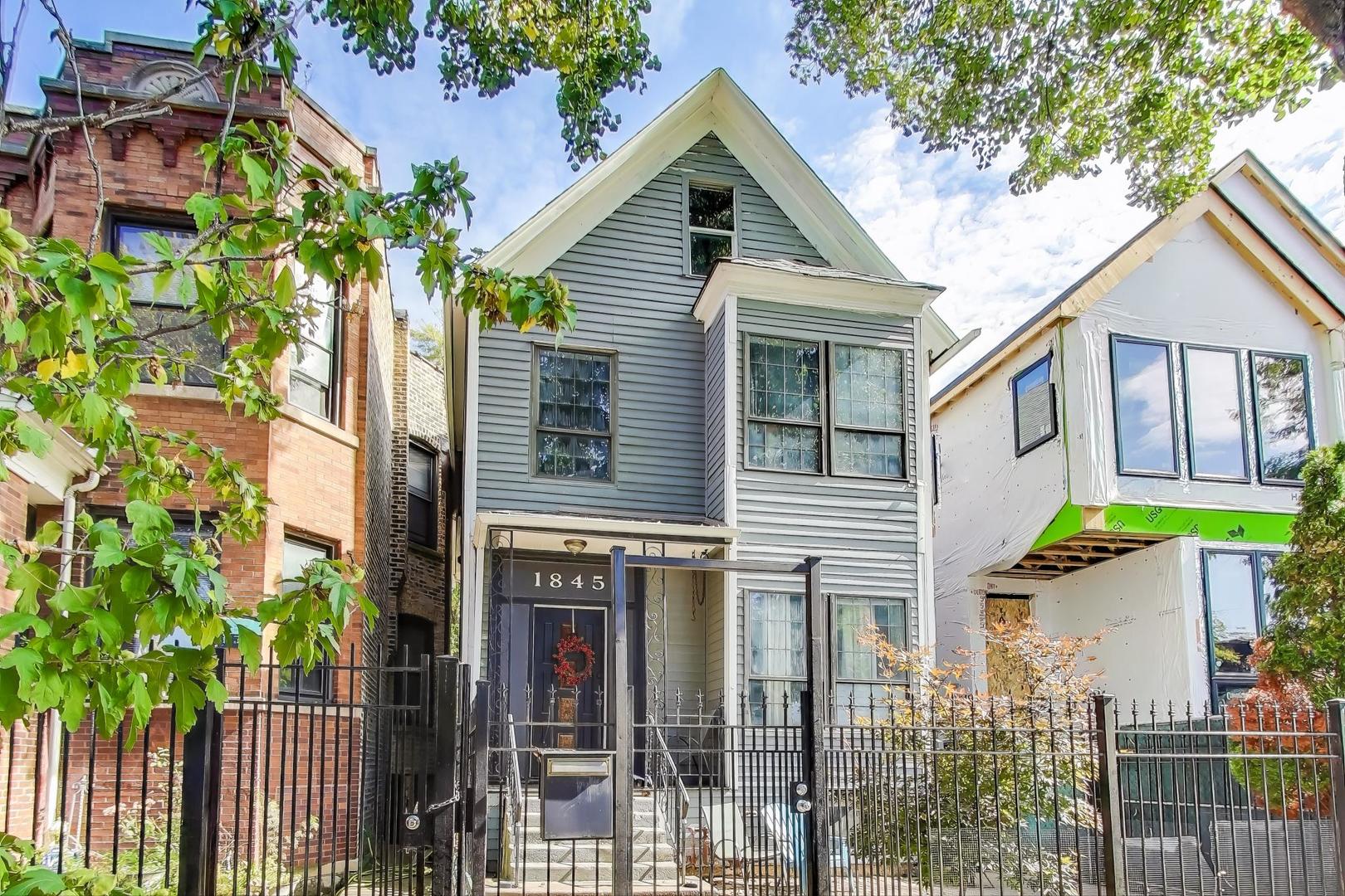 1845 North Albany Avenue, Unit 1 Chicago, IL 60647 - Photo 2 of 24 a view of a brick house with large windows and a small yard