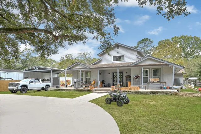 a front view of a house with garden and trees