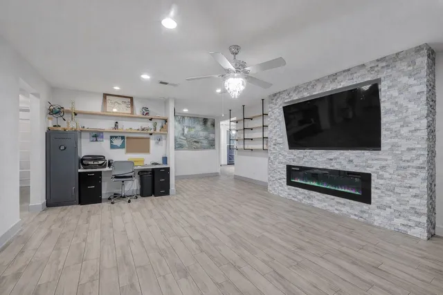 a living room with stainless steel appliances wooden floor and a kitchen view