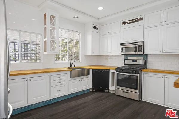 a kitchen with stainless steel appliances granite countertop a stove a sink and a microwave